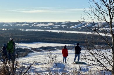 two people standing by the saskatchewan river